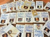 Plusieurs livres sont empilés sur une table devant une chaise.