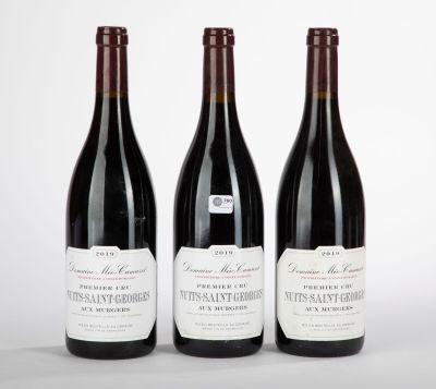 trois bouteilles de vin sont alignées sur une surface blanche