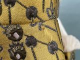 close up of a yellow dress with black and white flowers on it