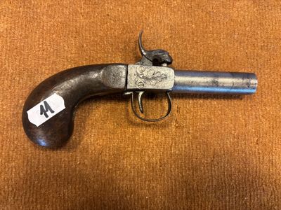 un vieux pistolet avec une étiquette, posé sur une surface brune
