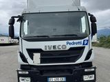 un camion blanc garé sur le bord de la route
