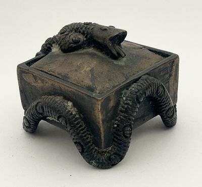 une petite boîte en bronze surmontée d'un lézard
