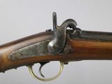 a close up of a rifle with a wooden barrel and brass fittings