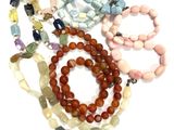 a lot of beads and bracelets on a white surface