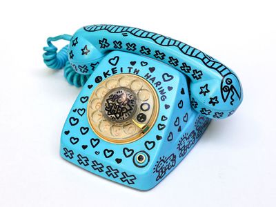 a blue phone with hearts on it sitting on a white surface