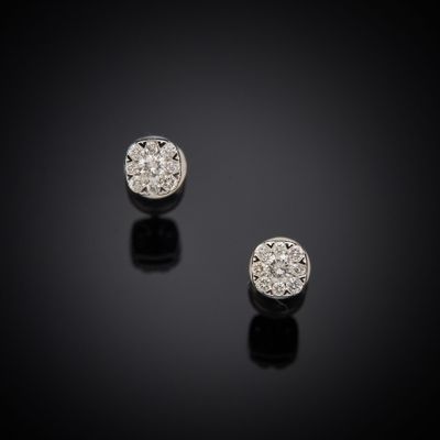 une paire de boucles d'oreilles en diamant posées sur une surface noire