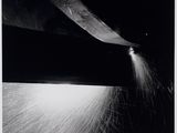 black and white photograph of a person cutting a piece of paper with a large knife