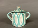 a close up of a teapot with a lid on a table