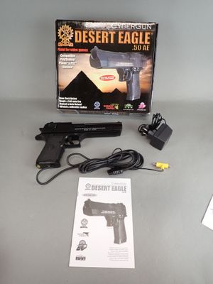 a desert eagle gun with a box and charger on the table