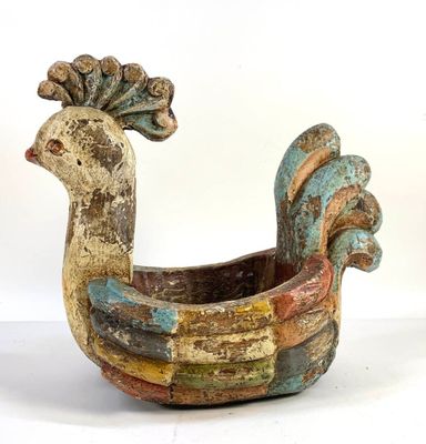 a colorful bird shaped planter sitting on a white surface