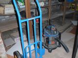 un diable bleu et un aspirateur dans une pièce