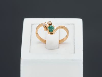 a close up of a gold ring with a green stone