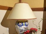 une lampe posée sur une table à côté d'un vase de fleurs