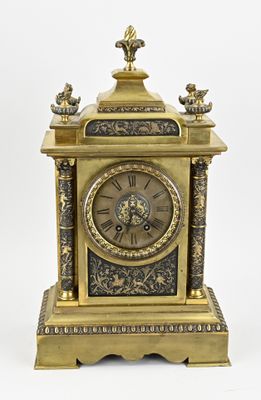 a gold clock sitting on top of a table