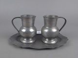 une paire de tasses et soucoupes en métal argenté, présentées sur un plateau en argent