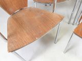 four wooden chairs sitting in a room with a white floor