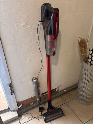 un aspirateur posé sur le sol à côté d'une poubelle