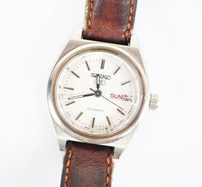 une image d'un gros plan d'une montre-bracelet sur une surface blanche