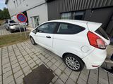 a small white car parked in front of a building