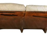 pair of leather and upholstered sofas with pillows on them