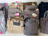 a lot of clothes and a bag on the table