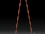 une lampe à trépied en bois surmontée d'un abat-jour noir
