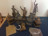 a lot of bronze figurines sitting on a blue table