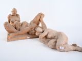 two figurines of a man and a woman laying on the ground