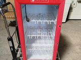 a small red refrigerator that is sitting in a garage