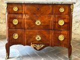 a dresser with a marble top on a brick floor