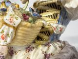 a figurine of a woman holding a basket of flowers