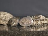 a silver bracelet and a silver ring on a table