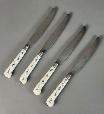 four knives with blue and white designs on them sitting next to each other