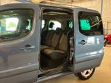 a small blue van with its doors open in a garage
