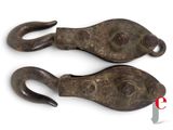 pair of antique iron hooks on a white background with a red ribbon