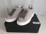 a pair of grey sneakers sitting on top of a black box