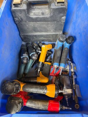 de nombreux outils divers dans un bac bleu posé par terre