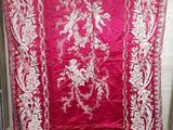 une vieille nappe rouge et blanche ornée d'un motif floral