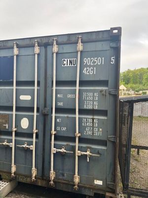 un conteneur bleu posé au bord d'une voie ferrée