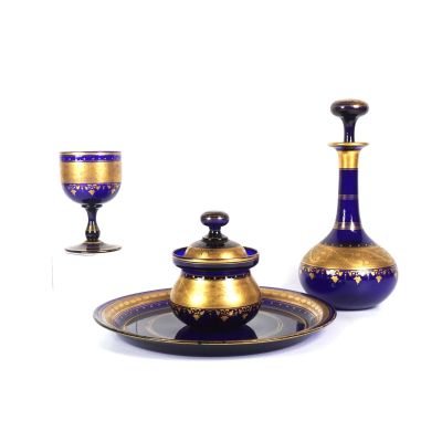 un service en verre bleu et or, composé d'une tasse et d'une soucoupe dorées