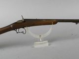an old rifle with a wooden barrel on a clear stand