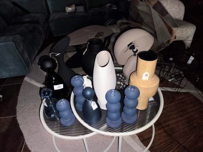 de nombreux vases de toutes sortes posés sur une table dans un salon