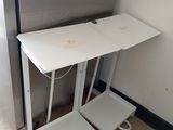 a small white table with two stools next to it