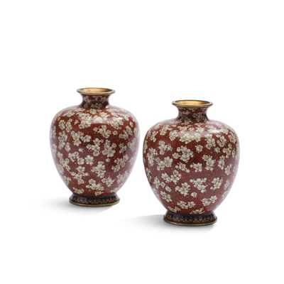 une paire de vases rouges et blancs posés sur une surface blanche