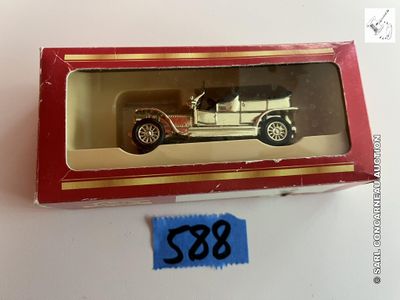 une petite voiture miniature dans une boîte rouge posée sur une surface blanche