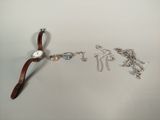 une montre et un bracelet posés sur une surface blanche