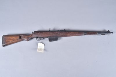 an old rifle with a wooden barrel and a tag on it