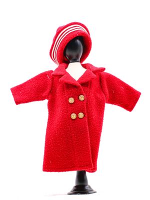 une poupée vêtue d'un manteau rouge et d'un chapeau
