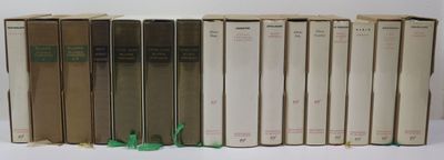 several books are lined up in a row on a white surface