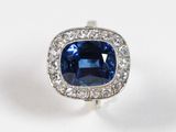 un gros plan sur une bague sertie d'un saphir bleu et de diamants
